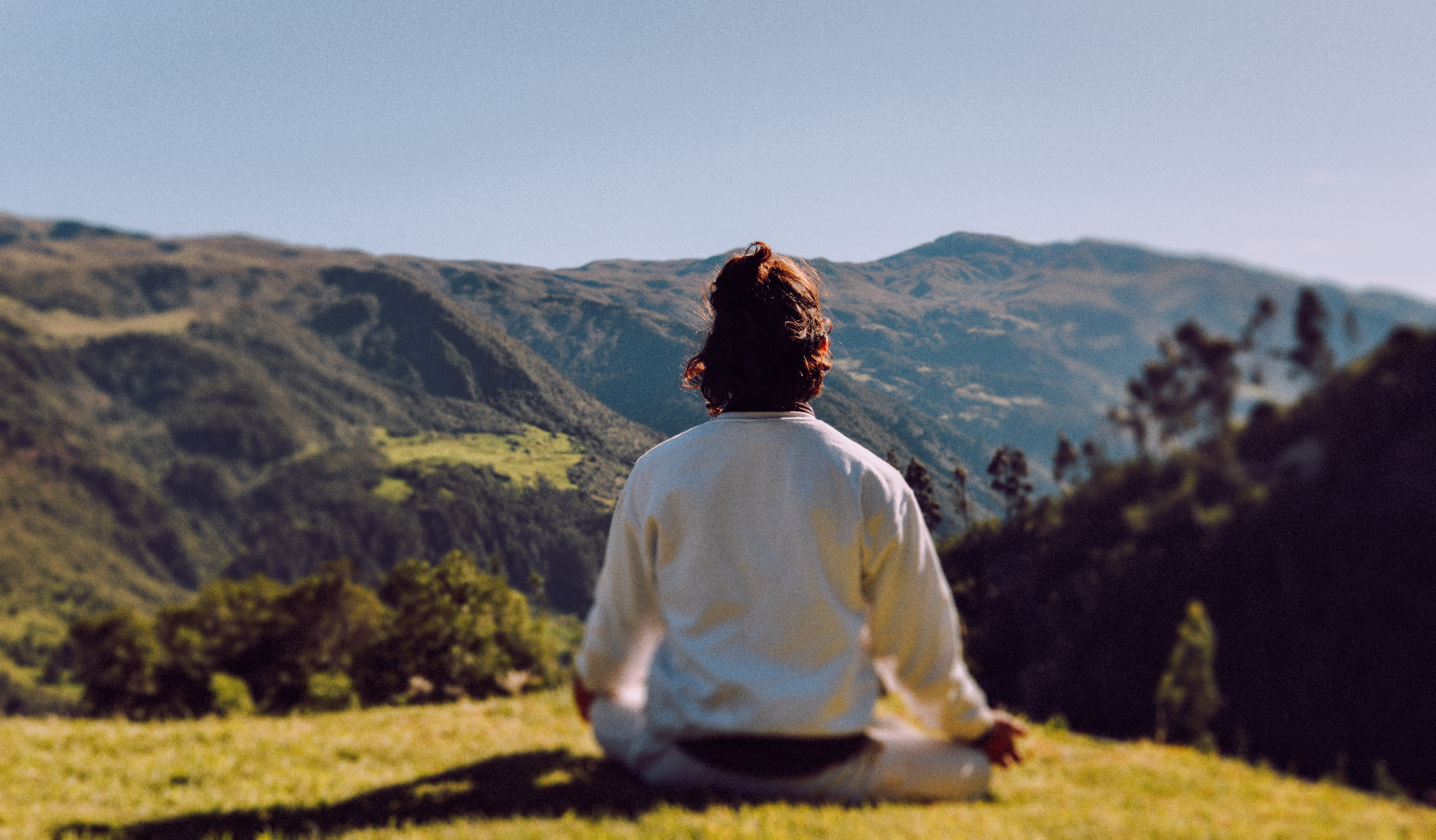 Meditación de espaldas, frente a la montaña